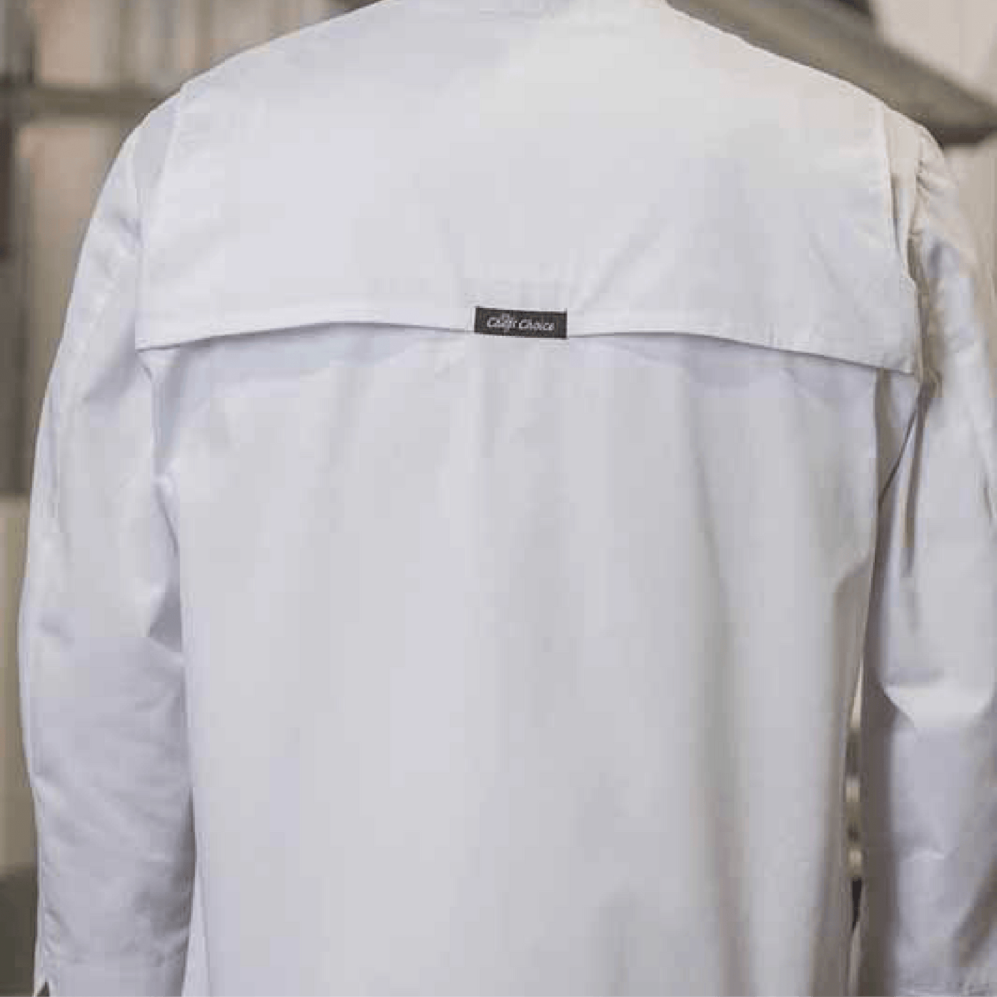 Back view of a white chef coat with mesh yoke and a center label reading 'Chef's Choice' beneath the upper back flap.