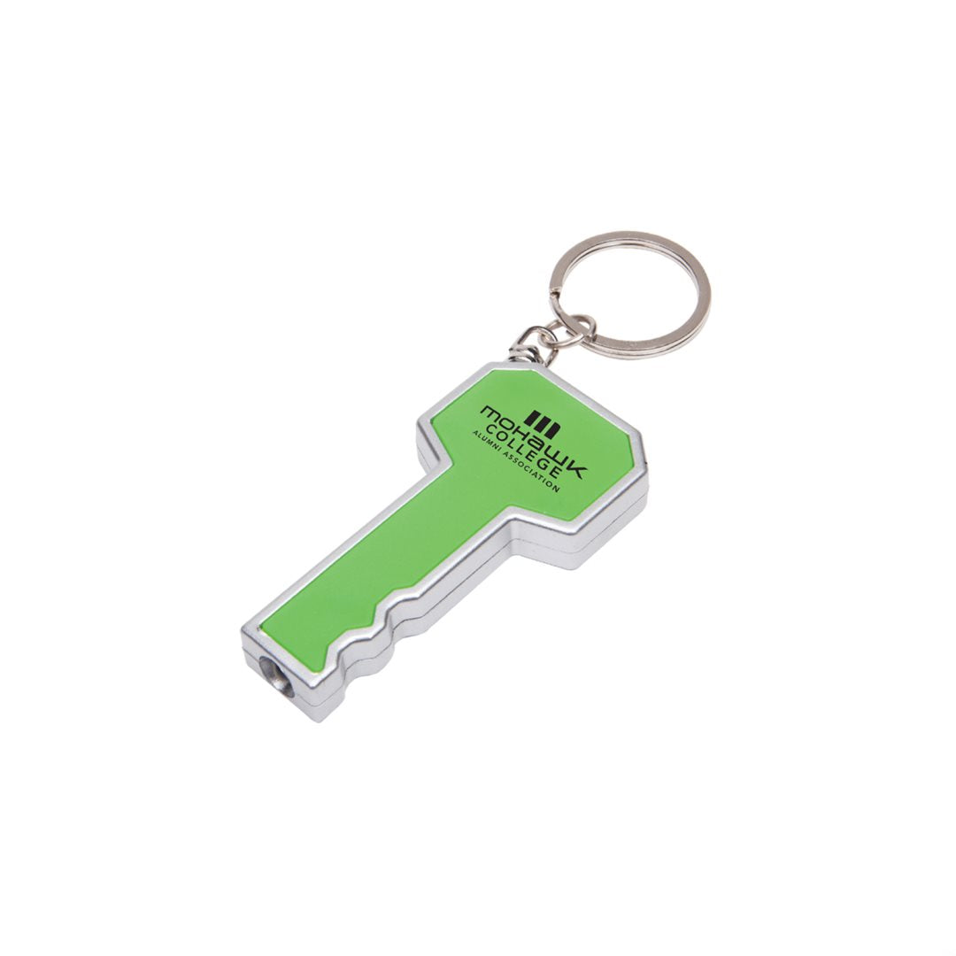 Key-shaped LED flashlight keychain in green and silver, featuring a black 'Mohawk College Alumni Association' logo on the head and a built-in white LED light at the tip; includes a metal keyring
