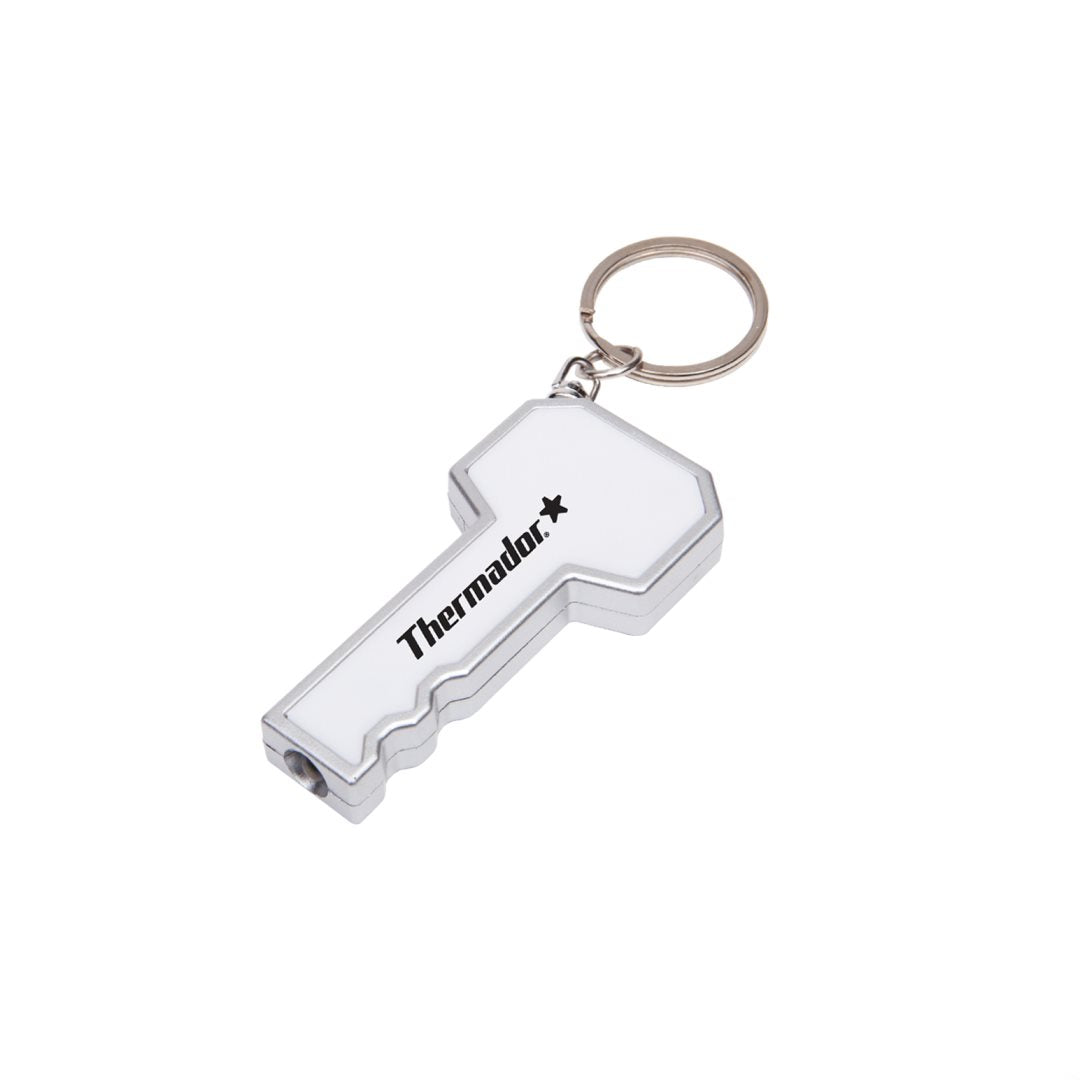 Key-shaped LED flashlight keychain in white and silver, featuring a black customized 'Thermador' logo on the head and a built-in LED light at the tip; includes a metal keyring for portability