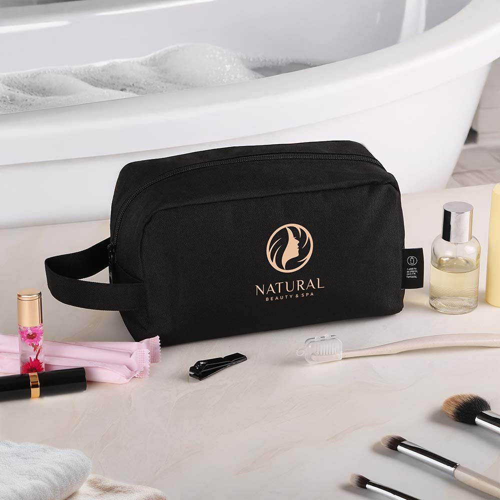 Black toiletry bag with custom Natural Beauty & Spa logo displayed on a bathroom counter