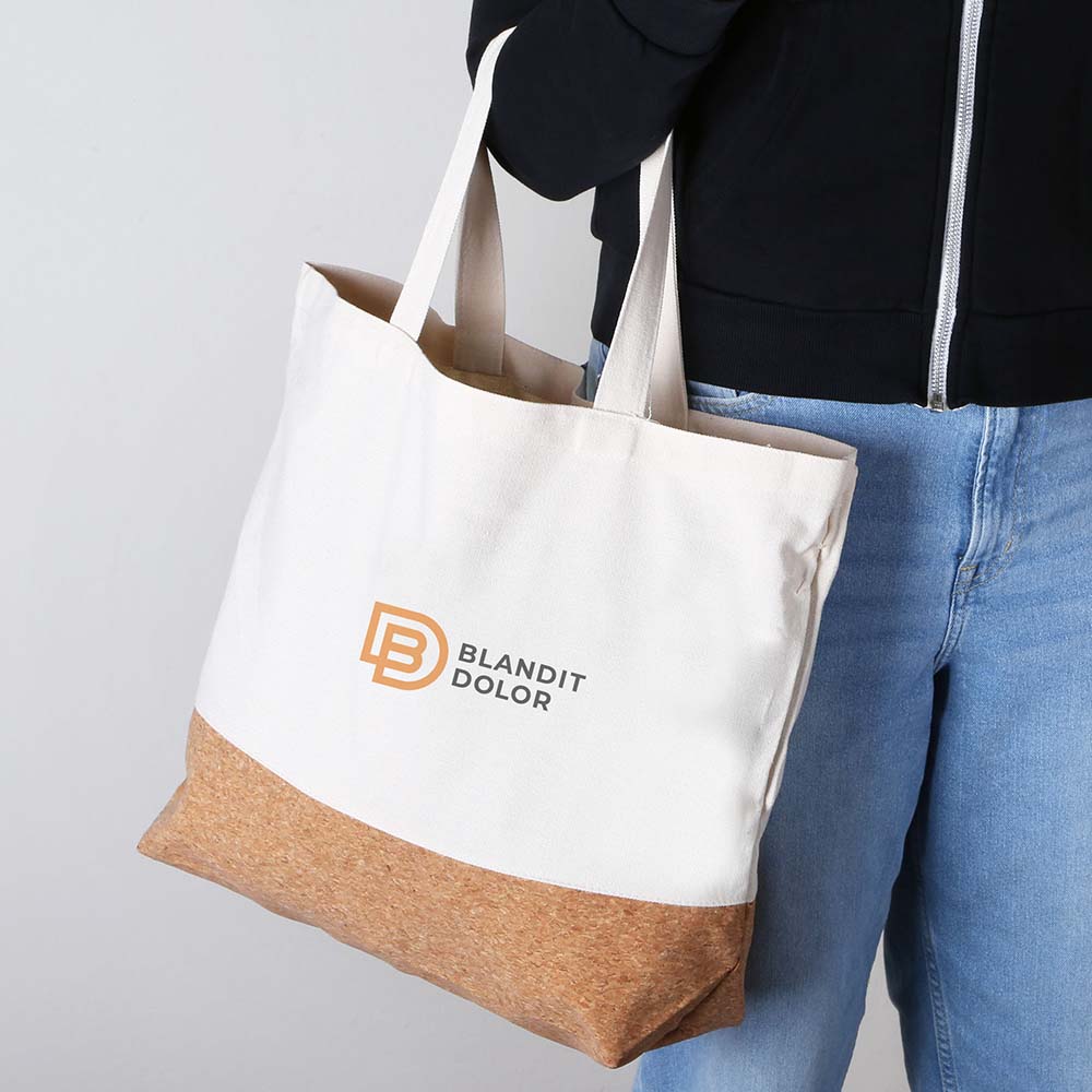 Close-up Side View of a Person Carrying a Beige Canvas Tote Bag with Cork Bottom and Custom Logo.