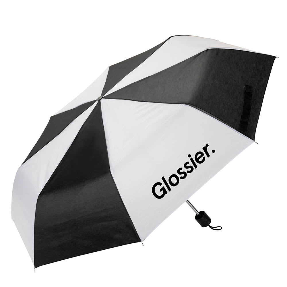 Black and white striped umbrella with the “Glossier.” logo printed on a white panel, featuring a compact black handle with wrist strap.