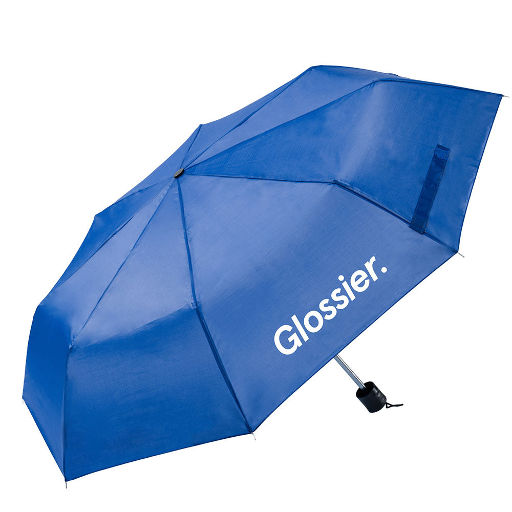 Blue umbrella with the “Glossier.” logo printed in black on one panel, featuring a compact black handle and wrist strap.