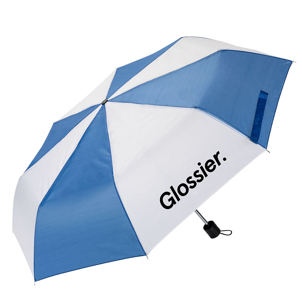 Blue and white striped umbrella with the “Glossier.” logo printed on a white panel, featuring a compact black handle and wrist strap.