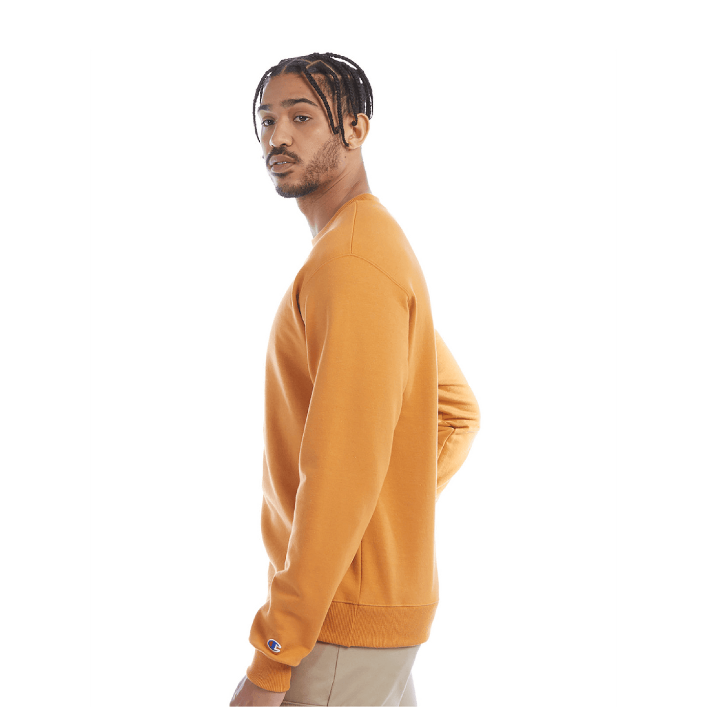 Side view of a man wearing a golden yellow crewneck sweatshirt and beige pants, with visible Champion logo on the cuff.