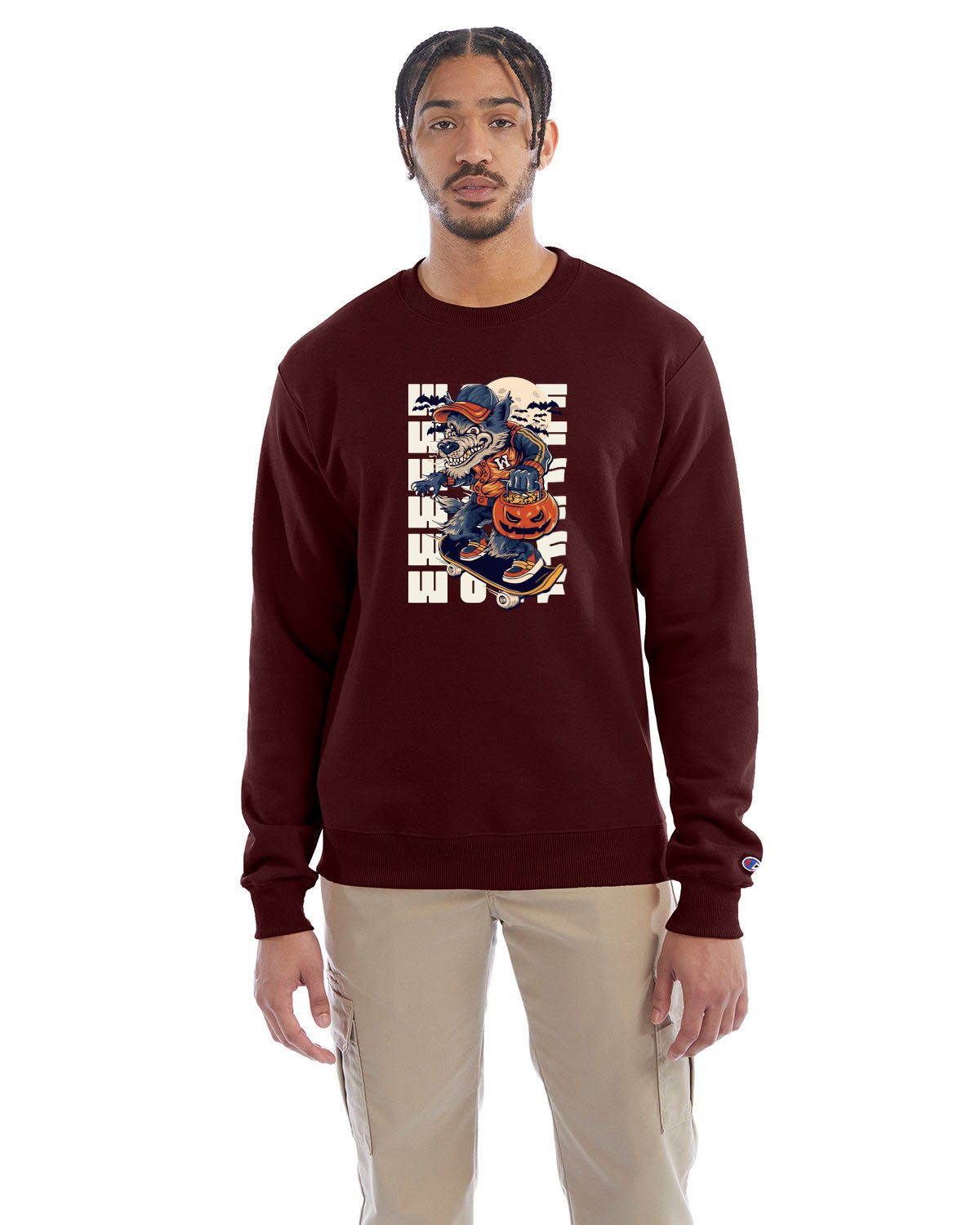 Maroon crewneck sweatshirt with a Halloween-themed graphic of a cartoon werewolf skateboarding with a pumpkin basket, worn by a model in beige pants.