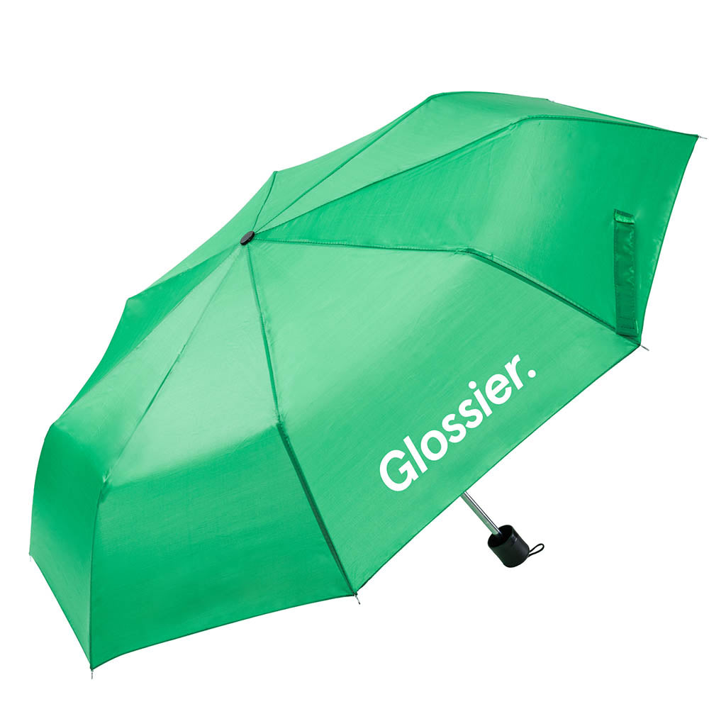 Green umbrella with the “Glossier.” logo printed in white on one panel, featuring a compact black handle and wrist strap.