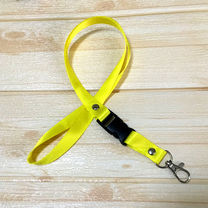 Yellow custom nylon lanyard with a detachable plastic buckle, silver button snaps, and a metal lobster clip, arranged in a loop on a white background.