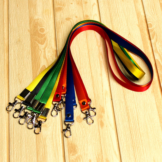 Assorted Custom Nylon Lanyards in multiple colors, each featuring two metal lobster clips and durable stitched ends, displayed on a light wooden surface