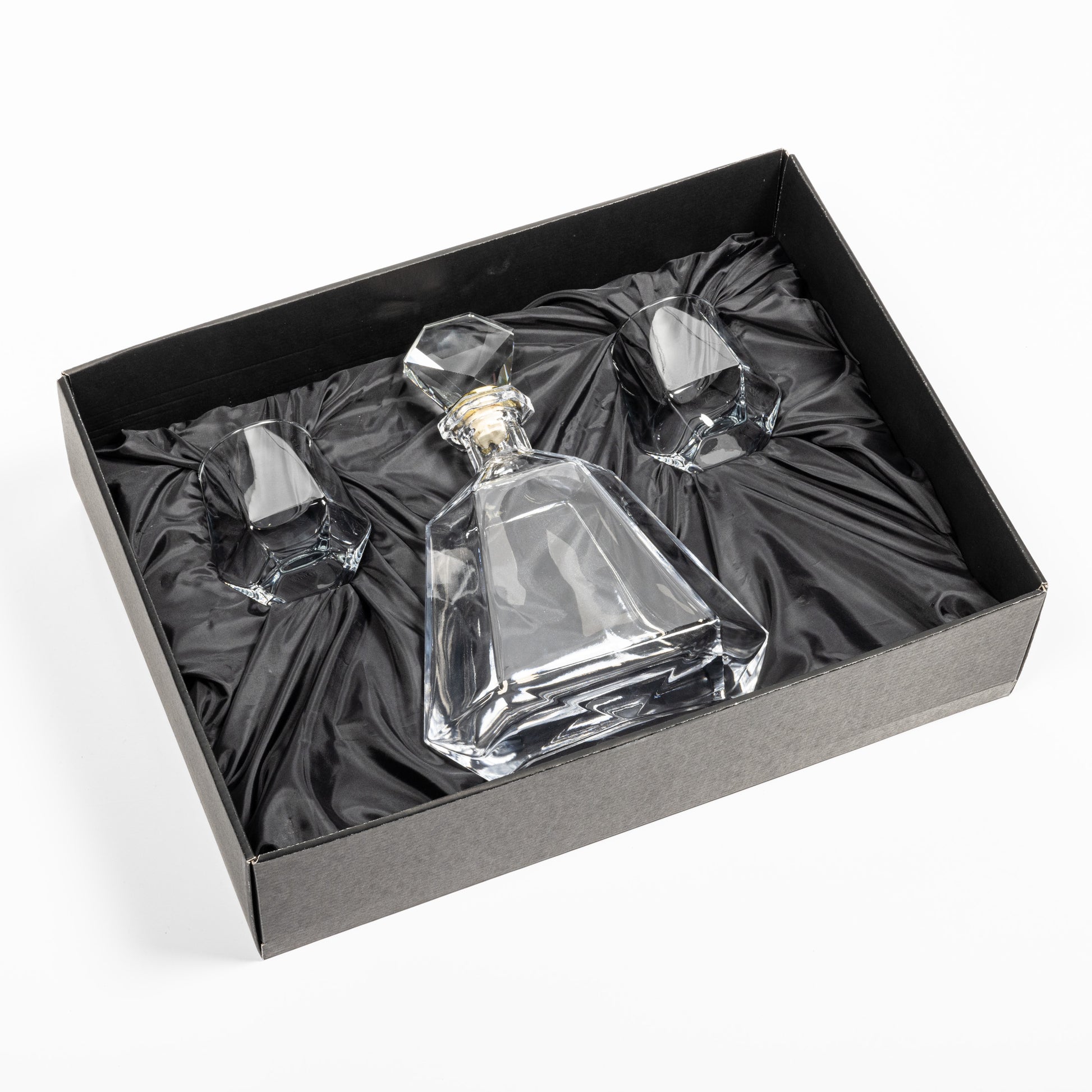 Crystal clear Hartsdale Decanter Set in an elegant black gift box with satin lining, featuring one faceted decanter and two matching whiskey glasses securely nestled inside.