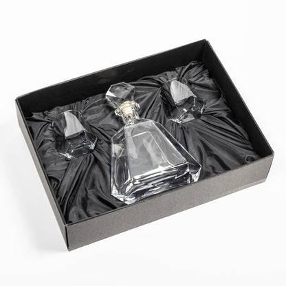 Crystal clear Hartsdale Decanter Set in an elegant black gift box with satin lining, featuring one faceted decanter and two matching whiskey glasses securely nestled inside.