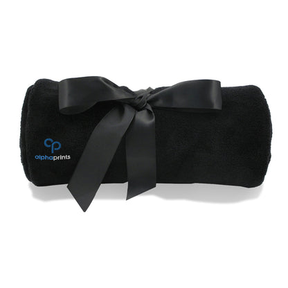 Rolled black blanket tied with a satin ribbon and embroidered with the 'alphaprints' logo.