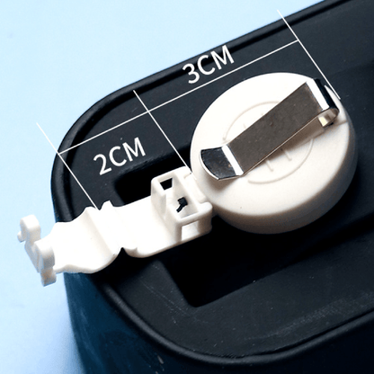 Close-up of a white retractable badge reel with metal clip, attached to a plastic mount with size measurements labeled as 2CM and 3CM, placed on a black surface with a light blue background.