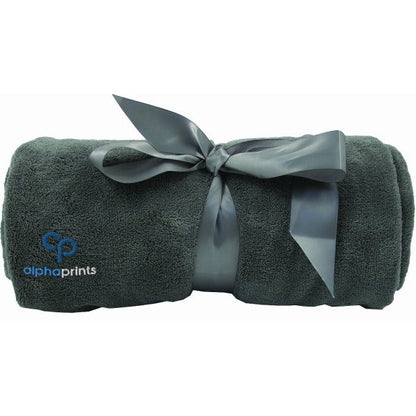 Rolled grey plush blanket tied with a satin ribbon and embroidered with the 'alphaprints' logo.