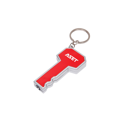 Key-shaped LED flashlight keychain in red and silver, featuring a bright white light at the tip and a customized 'ASET' logo printed on the head; includes a metal keyring for easy attachment.