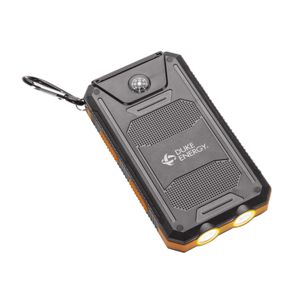 Black rugged solar power bank with a built-in compass, dual LED flashlights, and a carabiner; features the white "Duke Energy" logo on the front panel.