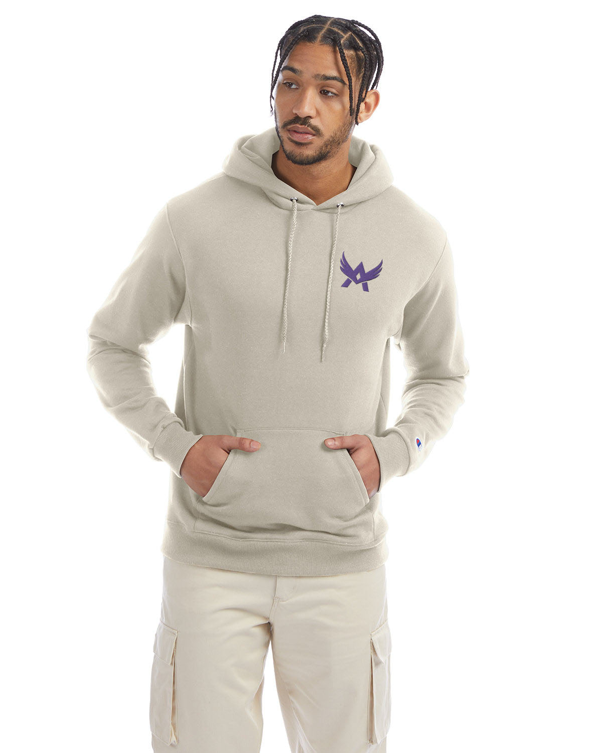 Model wearing a sand Champion hoodie with a front kangaroo pocket and a purple abstract winged logo on the left chest