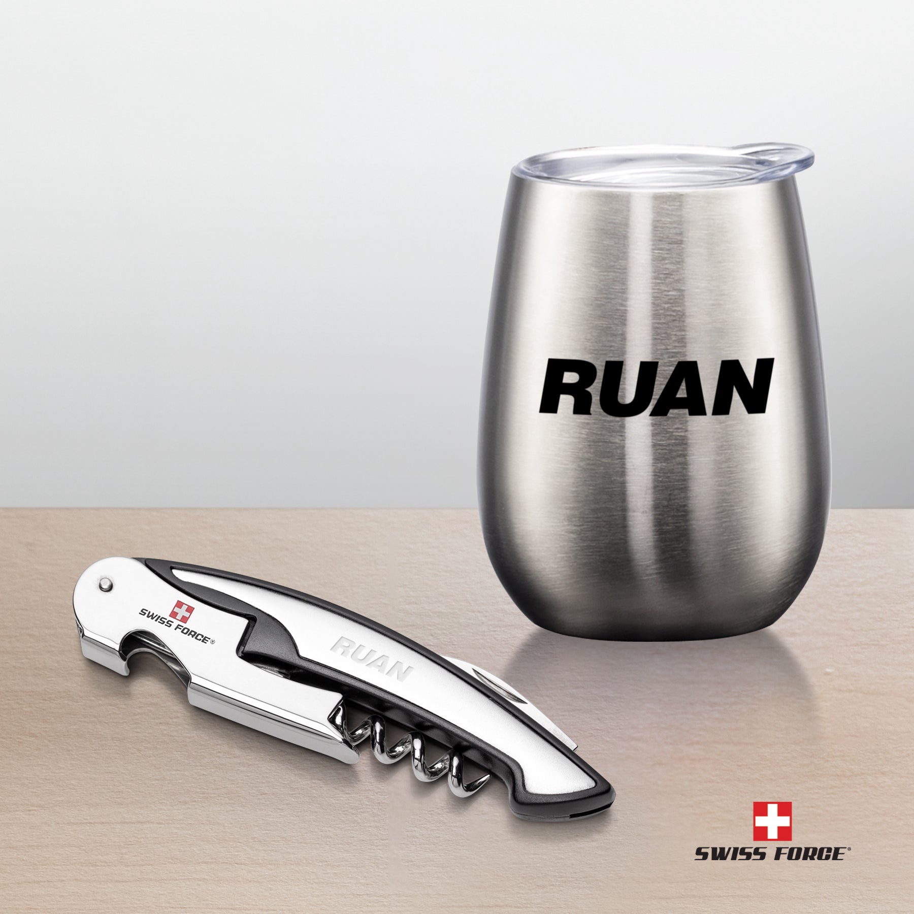 Swiss Force® Rosette Wine Gift Set featuring a stainless steel wine tumbler with 'RUAN' printed logo and a laser-engraved corkscrew bottle opener, both presented on a wooden surface
