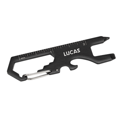 Back angle of the Claude Multi Tool with built-in inch ruler, showing the multi-functional black metal tool with carabiner clip, screwdriver, bottle opener, wrench slots, and 'LUCAS' logo engraving
