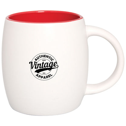 White ceramic mug with red interior, featuring a circular logo in black.