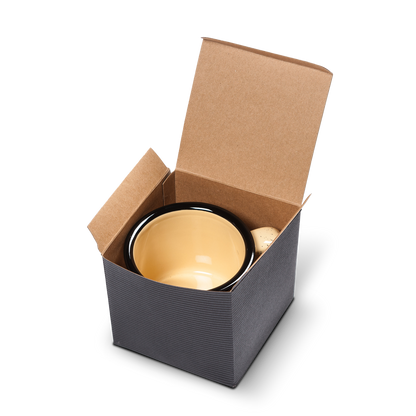 Beige ceramic campfire mug with a black rim, neatly packed in a kraft paper gift box with flaps open.