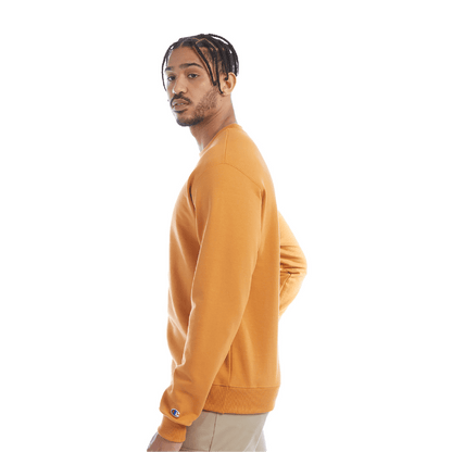 Side view of a man wearing a golden yellow crewneck sweatshirt and beige pants, with visible Champion logo on the cuff.