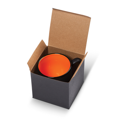 Matte black ceramic mug with bright orange interior, packaged in an open kraft gift box.