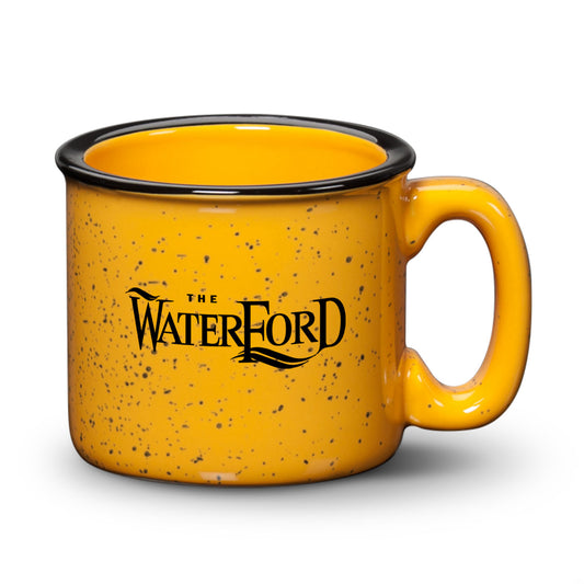 Gold ceramic campfire mug with a speckled finish, black rim, and print on demand logo