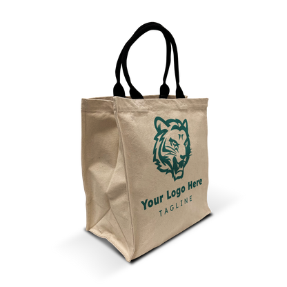 Angled view of a beige 12oz heavy-duty canvas grocery tote bag with green tiger logo and customizable text, featuring black rope handles and reinforced side gussets for extra capacity.