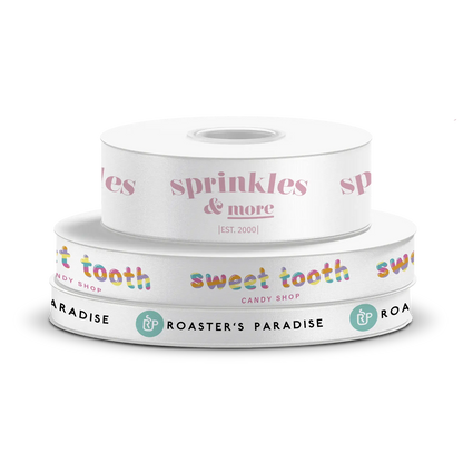 Stack of three custom white ribbon spools featuring various brand designs 