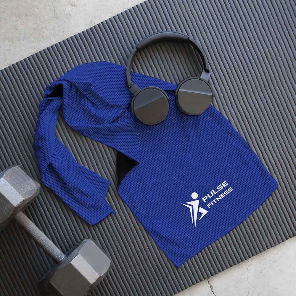 Blue cooling gym towel with 'Pulse Fitness' logo, placed on a black yoga mat alongside a pair of black headphones and a dumbbell