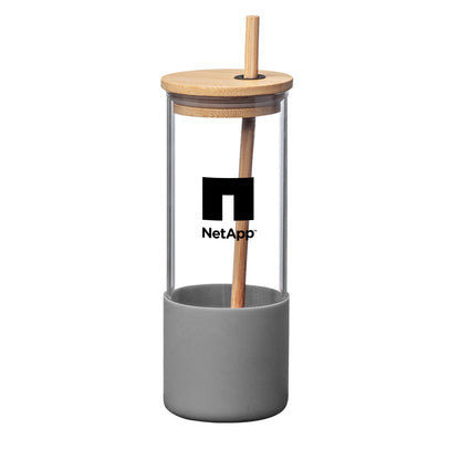 Reusable glass tumbler with a bamboo lid and straw, featuring a grey silicone base and a black NetApp logo printed on the front.