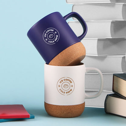 Stacked ceramic mugs with natural cork bottoms, one in navy and one in white, both featuring 'Ice Coffee Cold Brew' logos.